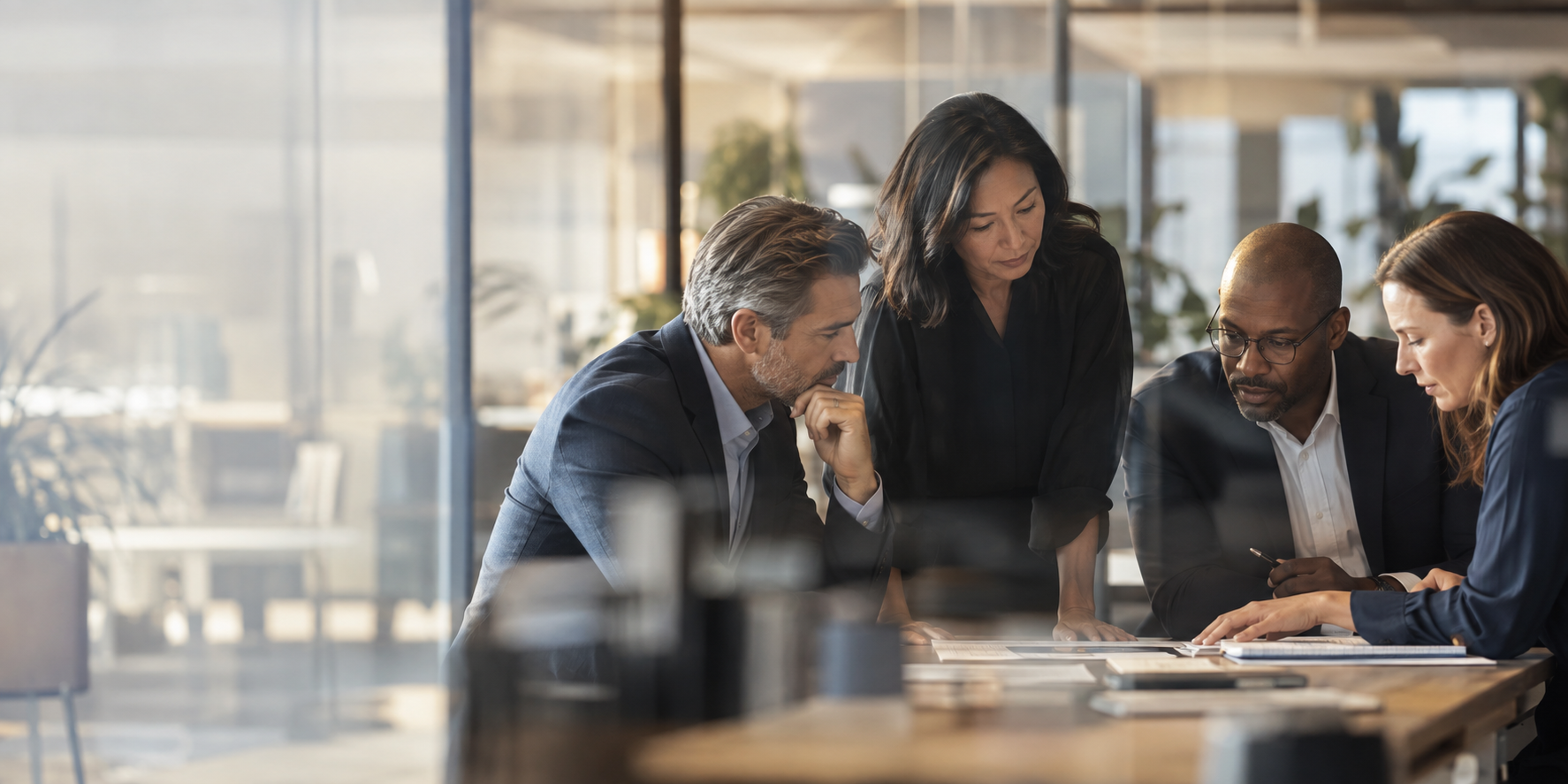 A leadership team examining information together through a glass partition